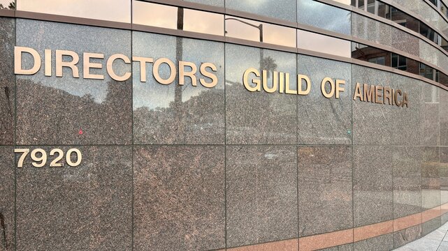 HOLLYWOOD, CA, APR 30, 2025: Directors Guild of America building signage with curved granite wall, bronze lettering, address at 7920 Sunset Blvd, modern architectural design