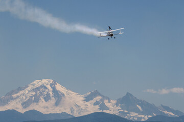 Naklejka premium A person standing in an airplane with a mountain in the background