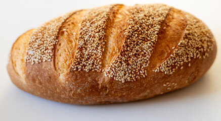 Freshly baked sesame bread loaf, showcasing a golden brown crust and a soft interior.