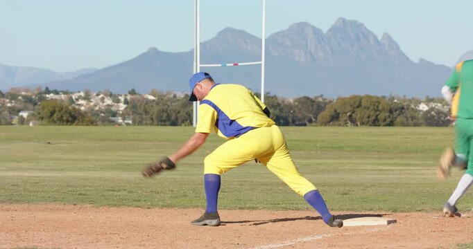 Catching infielder throw at first base, first baseman jogging toward diverse teammates celebrating