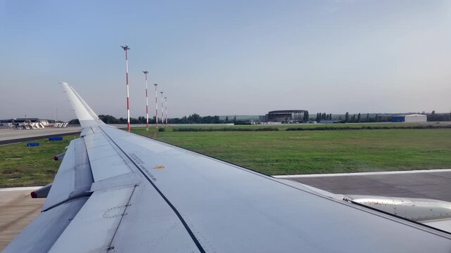 View of the airplane wing from window seat moving through the Chisinau International Airport