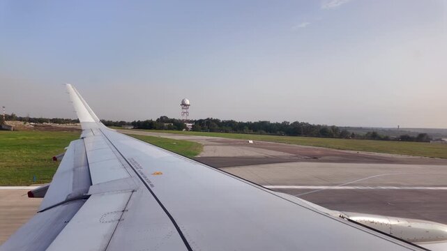 View of the airplane wing from window seat moving through the Chisinau International Airport