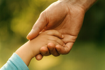 Close-up of hands held together in the sunlight, showing connection