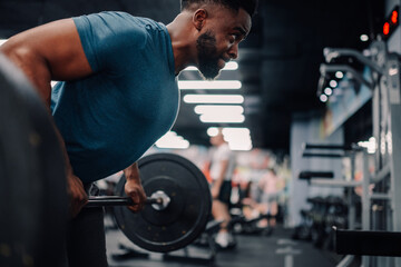 Determined male athlete lifting weights, achieving fitness goals in gym