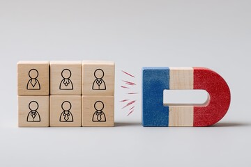 Wooden blocks with business icons attracting a magnet