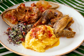 Traditional rustic Brazilian food, guinea fowl, Numida meleagris, with polenta, artisanal bread, and quinoa tabbouleh with vegetables. Real food