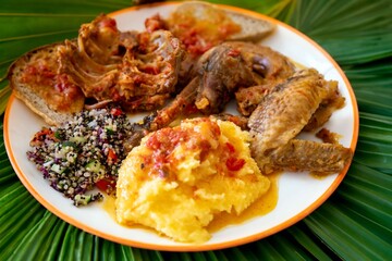 Traditional rustic Brazilian food, guinea fowl, Numida meleagris, with polenta, artisanal bread, and quinoa tabbouleh with vegetables. Real food