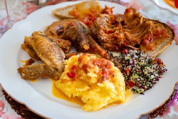 Traditional rustic Brazilian food, guinea fowl, Numida meleagris, with polenta, artisanal bread, and quinoa tabbouleh with vegetables. Real food
