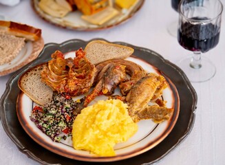 Traditional rustic Brazilian food, guinea fowl, Numida meleagris, with polenta, artisanal bread, and quinoa tabbouleh with vegetables. Real food