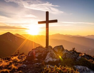 A wooden cross atop a mountain peak at sunset