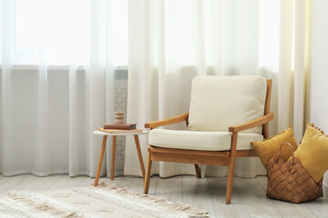 Stylish furniture near window with curtains in living room. Interior design