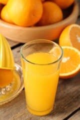 Tasty orange juice, fresh fruits and juicer on wooden table, closeup