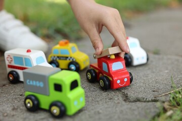 Obraz premium Little boy playing with toy cars outdoors, closeup