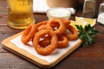 Fried squid rings served on wooden table, closeup