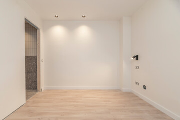 Open-plan room with solid wood flooring, where the sound of footsteps echoes in the silence