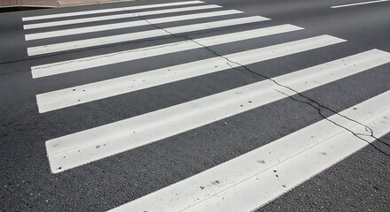 Fototapeta premium White stripes of a pedestrian crossing on asphalt road