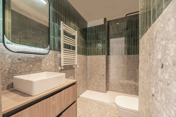 Hotel bathroom design with a rectangular porcelain sink, antique brass faucets, and a thresholdless walk-in shower enclosure