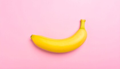 Single ripe banana on a pink background.