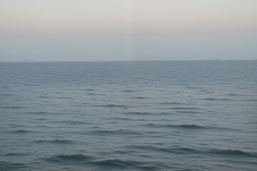 Obraz premium Serene Ocean View at Dusk with Gentle Waves and Soft Horizon