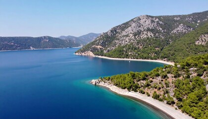 Obraz premium Expansive view of a tranquil bay with lush greenery and mountains.