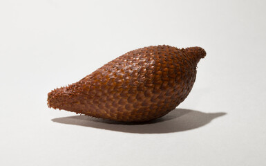 Salak (Salacca zalacca) is a species of palm tree (family Arecaceae), snake fruit or snakeskin fruit due. One fruit on a white background.