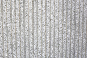Close-up of textured concrete wall with vertical grooves.