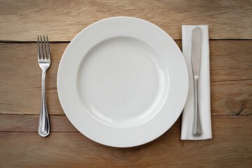 A white plate, fork, and knife on a wooden table. The setting is minimalistic and focused on dining essentials.