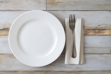 A white plate, fork, and folded napkin on a wooden table. The setting is minimalistic and clean, with a focus on the tableware and the texture of the wooden surface.
