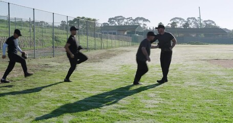 Gesturing male baseball team following senior coach gloving high-fiving jogging outfield for drill - Powered by Adobe