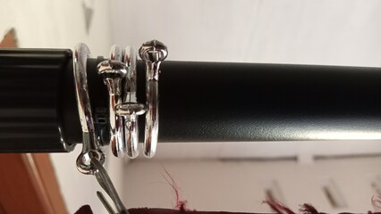Close up of shiny curtain rings on a dark curtain rod