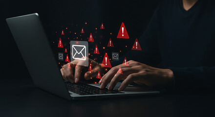 Cybersecurity threat alert with glowing red warning icons and email symbol over person typing on laptop