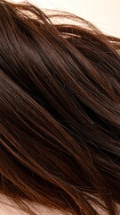 Fototapeta premium Close-up of dark brown, smooth hair strands, softly tousled