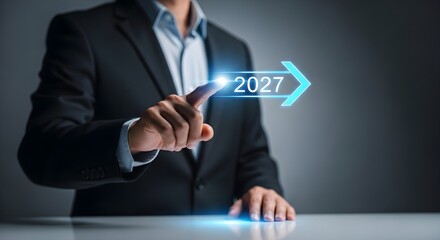 Businessman points to a digital arrow with "2027," representing future business planning and forward-looking strategy.