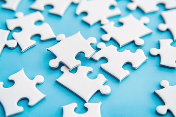 White puzzle pieces on blue background, problem solving concept