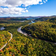 Obraz premium Aerial view of a winding river through autumnal forests and hills