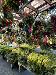 fresh boughs and evergreen wreaths for sale at a holiday market