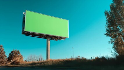 Roadside Advertising Billboard with Green Screen Mockup Filmed from a Moving Vehicle on a Sunny Day.