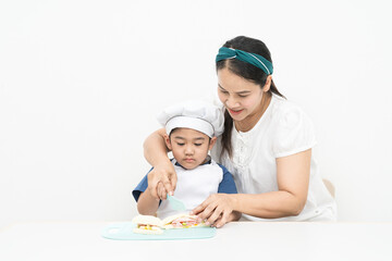 Mother is teaching her son to cook to develop life skills.