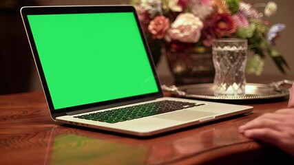 Laptop on Table with Green Screen in Cozy Environment