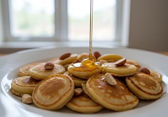 Mini pancakes served with honey drizzle and crunchy almond slices