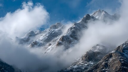 The mountain range is covered in clouds, creating a moody and serene atmosphere. The misty mountains are a beautiful sight, and the clouds add a sense of mystery and depth to the landscape