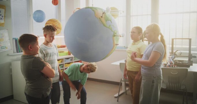 Environmental Science Lesson: Primary School Children Talking, Looking at Earth Model. Talented Kids Learning Geography, Ecology and Renewable Energy Resources in Classroom. Interactive STEM Education