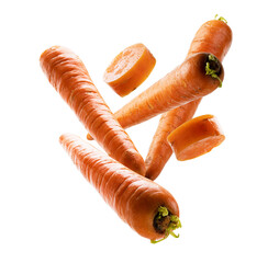 Ripe carrots whole and sliced levitate on a white background
