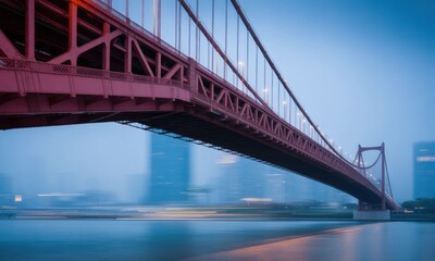 Fototapeta premium Pink bridge spanning a river at dusk