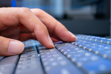 Close-up of hand typing on sleek keyboard in blurred workspace—perfect for tech ads highlighting human–computer interaction, digital workflow, and smart productivity.