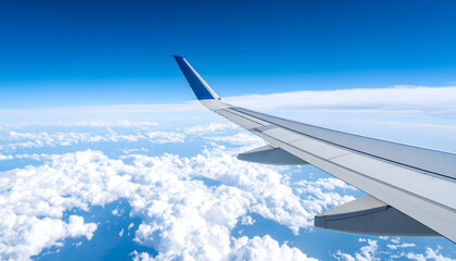 Fototapeta premium Airplane Wing Flying Above White Clouds in Blue Sky during Daylight Aerial View of Flight