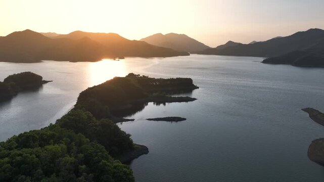 Cinematic Aerial backward Drone Shot of Sunset Over Chungju Lake: Peaceful Water, Scenic Islands, and Golden Sunlight Reflections