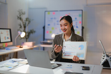 Professional female executive reviewing financial data while video conferencing in contemporary workplace setting