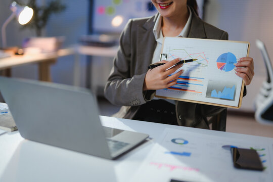 Professional working remotely, gesturing toward performance data during virtual team meeting