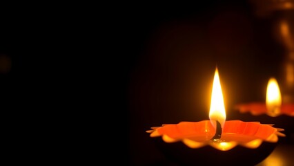 Golden diya glowing in darkness, symbolizing tradition and festive spirit in Indian culture.